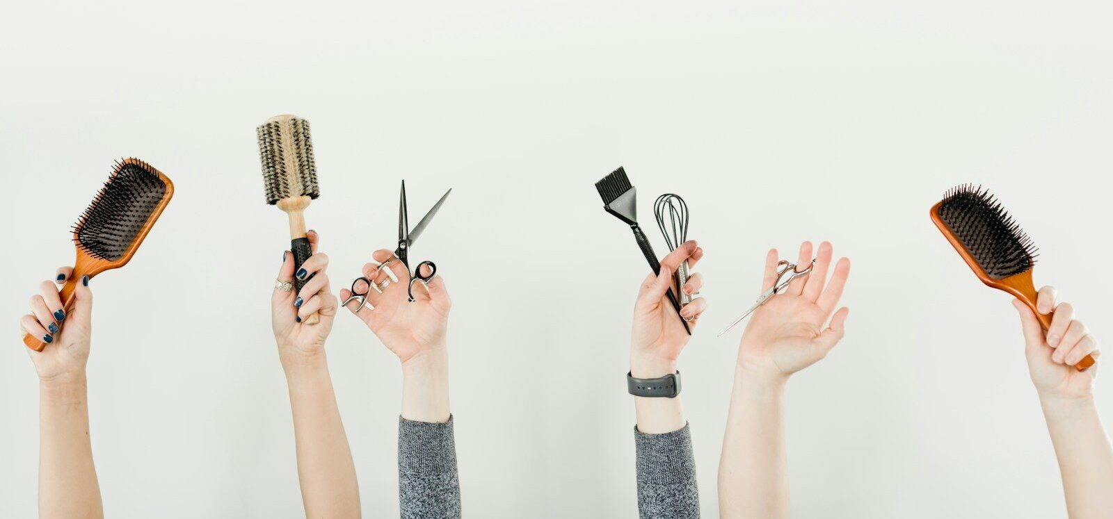 person holding silver and black hair brush